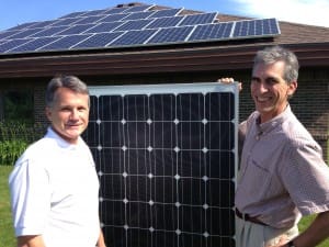 Hertzler Systems Inc. co-owners Byron Shetler (left) and Evan Miller display one of the nearly 50 solar panels used in the solar energy project at their Goshen, Indiana, headquarters. Shetler is Hertzler's Chief Technology Officer. Miller is President and CEO. 